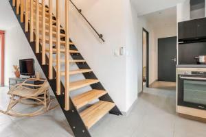 a staircase in a living room with a kitchen at Comme à la maison ! in Matour