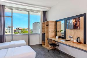 a hotel room with a bed and a desk with a window at Dedem Hotel Express-İstanbul Airport-Round Trip Airport Service in Arnavutköy