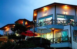 a large building with an umbrella in front of it at Buan Badatgaeui Chuoek Pension in Buan