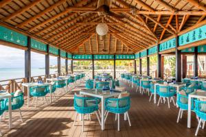 a dining room with blue chairs and tables at Sanctuary Cap Cana, a Luxury Collection Resort, Dominican Republic, Adult All-Inclusive in Punta Cana