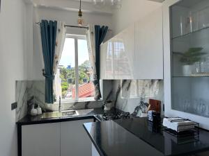 a kitchen with white cabinets and a window at Kandana bliss villa in Kandana +20 photos