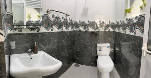 a bathroom with a sink and a toilet and a mirror at Kandana bliss villa in Kandana