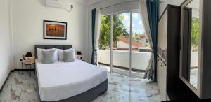 a bedroom with a large bed and a balcony at Kandana bliss villa in Kandana
