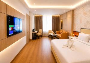 a hotel room with a bed and a tv at Pride Premier Greater Noida in Noida