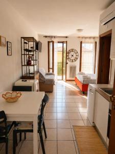 a kitchen and living room with a table and a room at BeaMare - Monolocale - Massimo tre ospiti con posto spiaggia - Studio Apartment - Max 3 people with 1 private umbrella and two SunBeds at the private beach of Eraclea Mare in Eraclea Mare