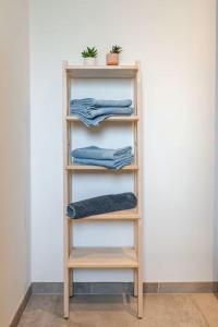 a wooden shelf with blue towels on it at Comme à la maison ! in Matour