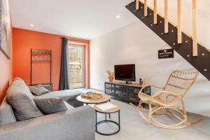 a living room with a couch and a tv at Comme à la maison ! in Matour