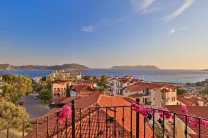 a view of a town with pink flowers on a balcony at Çınarlar Apart KC Blok in Kaş