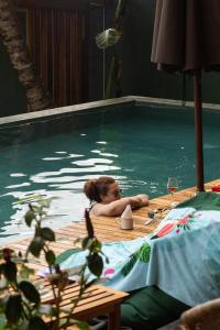 a woman laying in a swimming pool at Coast 67 Boutique Hotel in Ahangama