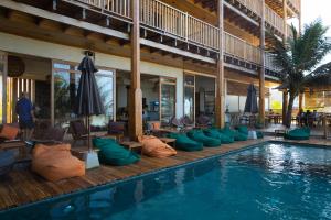 a pool with chairs and umbrellas next to a resort at Coast 67 Boutique Hotel in Ahangama