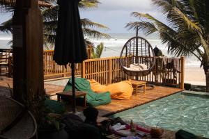 a patio with a hammock and a swing next to a pool at Coast 67 Boutique Hotel in Ahangama