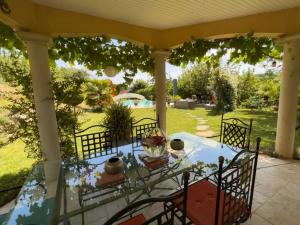 a table on a patio with a view of a yard at Maison d'hotes Dolce Vita in Veyssilieu