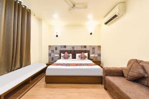 a bedroom with a bed and a couch at FabHotel Harsh Paradise - Malviya Nagar in Jaipur