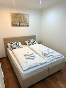 a bedroom with a large white bed with towels on it at Chata VeloVino in Moča