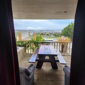 a picnic table on a balcony with a view at Shirleys Place in Brackenfell