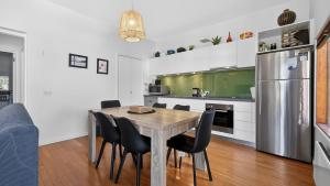 a kitchen with a table and chairs and a refrigerator at Triggerplant 2 in Dinner Plain