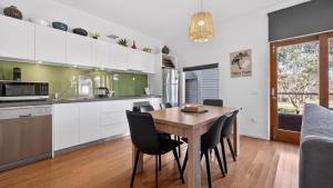 a kitchen and dining room with a wooden table and chairs at Triggerplant 2 in Dinner Plain