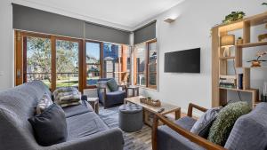 a living room with two couches and a tv at Triggerplant 2 in Dinner Plain