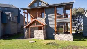 a house with a porch on the side of it at Triggerplant 2 in Dinner Plain