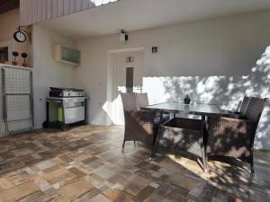 a dining room with a table and chairs and a stove at Apartment Jurček with jacuzzi & sauna in Luče