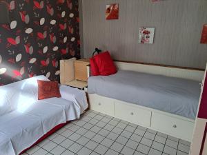 two beds in a room with boxes on the wall at Gite ETAPE A COUCY in Coucy-le-Château-Auffrique