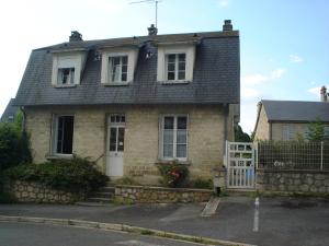 a brick house with a white door and a fence at Gite ETAPE A COUCY in Coucy-le-Château-Auffrique