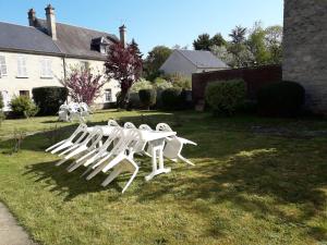 a group of white chairs sitting in a yard at Gite ETAPE A COUCY in Coucy-le-Château-Auffrique
