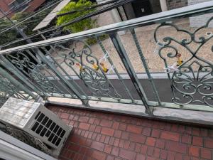 a metal railing on a balcony with a vent at Alia House 旅館 in Tokyo