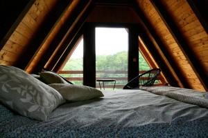 a bed in a room with a large window at A frame Svetosavska bajka in Lisice