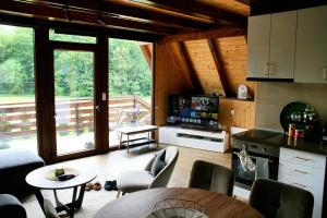 a kitchen and living room with a table and chairs at A frame Svetosavska bajka in Lisice