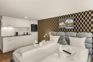 a living room with a white couch and a kitchen at BERG & BERG Hotel - Hellbühl Self-Check-in in Hellbühl
