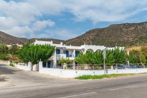 a white house with trees on the side of a road at Perasma Studios 12 in Kipri +12 photos