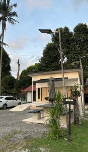 a building with a bench and a umbrella in front of it at Cerya Kampung Inn in Cherating +6 photos