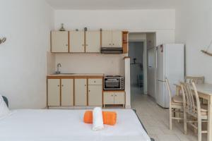a room with a kitchen with a bed and a refrigerator at Perasma Studios 12 in Kipri