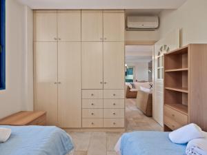a bedroom with white cabinets and a blue bed at Neptune Suite Sounio in Sounio