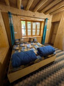 a room with a bed with blue pillows in it at Turtuk Stream Side Home Stay in Turtuk
