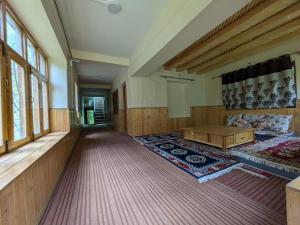 an empty room with wooden walls and windows at Turtuk Stream Side Home Stay in Turtuk