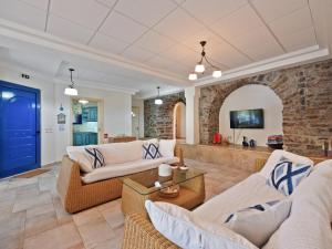 a living room with white furniture and a blue door at Neptune Suite Sounio in Sounio