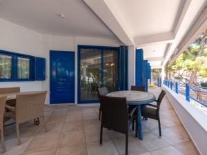 a dining room with blue doors and a table and chairs at Neptune Suite Sounio in Sounio