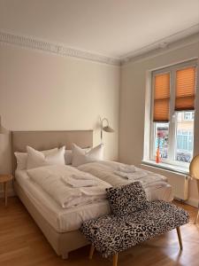 a white bedroom with a bed and a chair at Schlaflounge in Hamburg