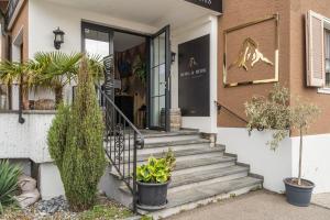 a building with stairs and plants in front of it at BERG & BERG Hotel - Hellbühl Self-Check-in in Hellbühl
