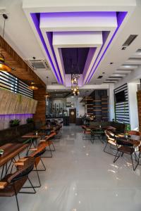 a restaurant with tables and chairs and purple lighting at Hotel Lajka Luxury in Ulcinj