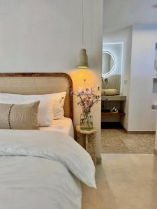 a bedroom with a bed and a vase of flowers on a table at Vida Lenta Boutique Finca in Alora