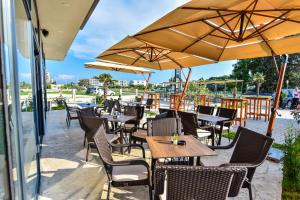 an outdoor patio with tables and chairs and umbrellas at Hotel Lajka Luxury in Ulcinj