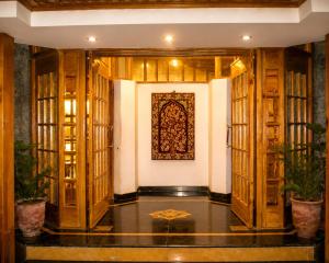 a hallway with wooden doors and a painting on the wall at Hotel Meridien Riverfront in Srinagar