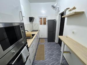 a kitchen with white walls and a black refrigerator at Villa Djenné électricité 24h in Bamako