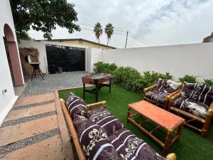 a backyard with couches and a table and a screen at Villa Djenné électricité 24h in Bamako