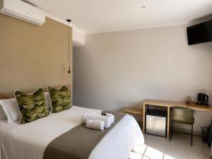 a bedroom with a bed with a stuffed animal on it at Hanan Guesthouse in Thabazimbi