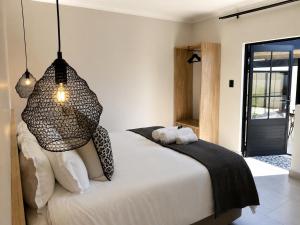 a bedroom with a white bed with black and white pillows at Hanan Guesthouse in Thabazimbi