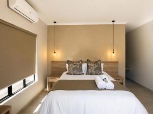 a bedroom with a bed with two towels on it at Hanan Guesthouse in Thabazimbi +1 photo